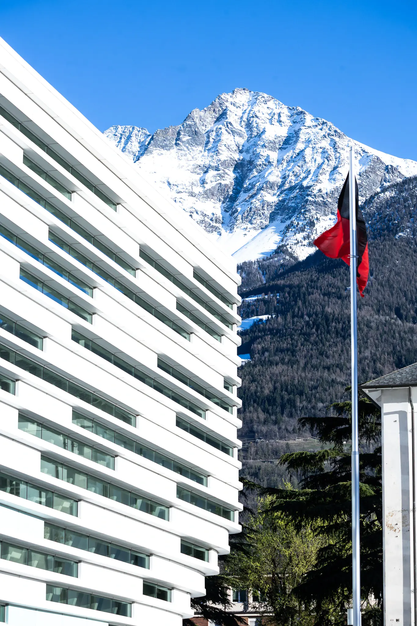 Università della Valle d’Aosta con la bandiera regionale e le montagne sullo sfondo